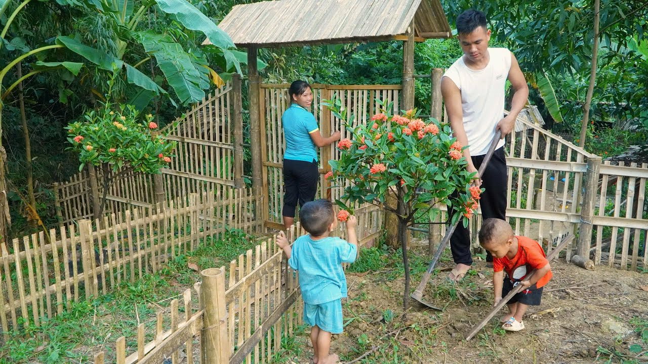 A single mother - together with him, closed the gate and planted flowers to decorate the new house.