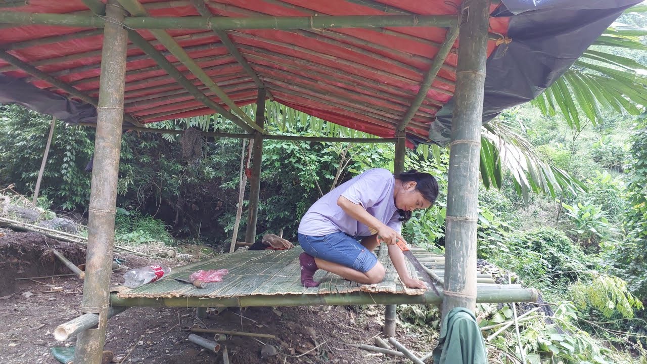 alone, roofing the house with tarpaulin, making the roof of the house with bamboo