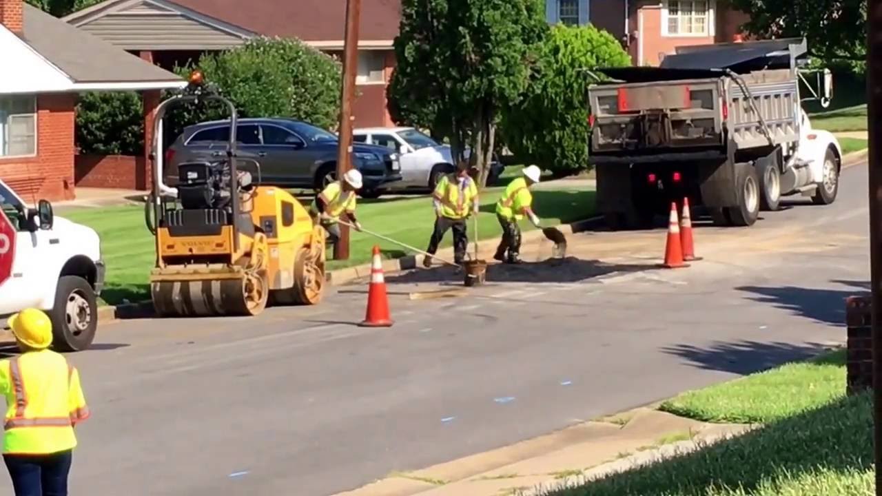 Utility road crew putting asphalt to street surface