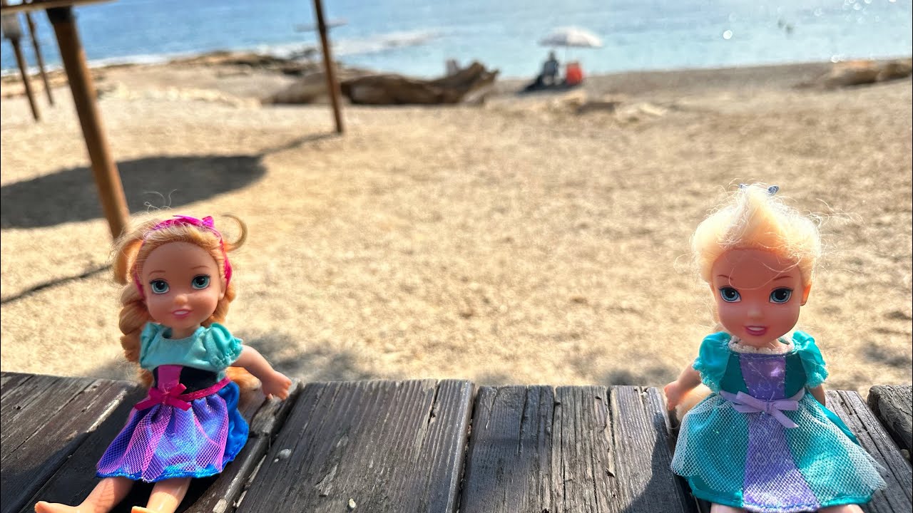 Elsa and Anna toddlers play in the sand