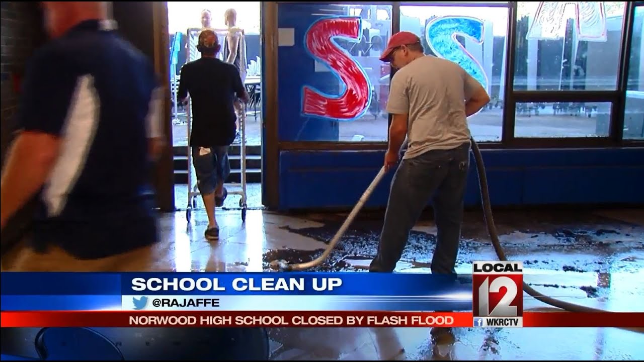 Norwood school employees and volunteers work to clean up after flooding