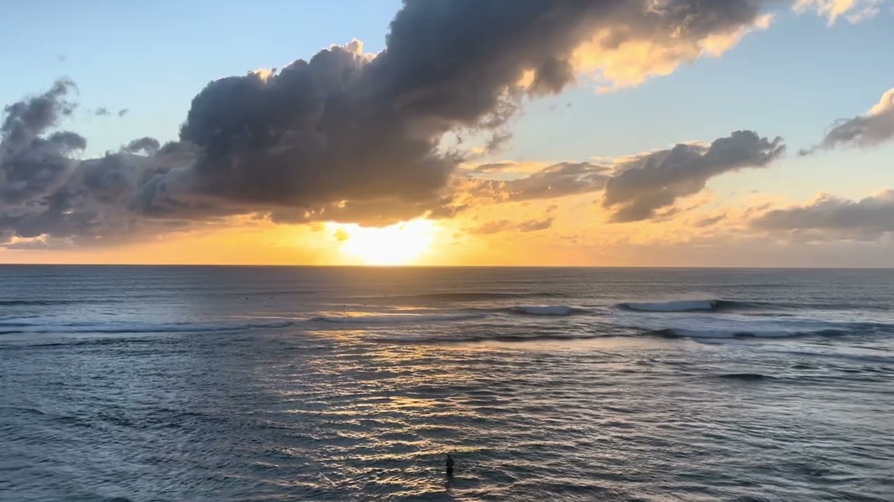 Swimmers under a golden sunset in Yallingup, Western Australia