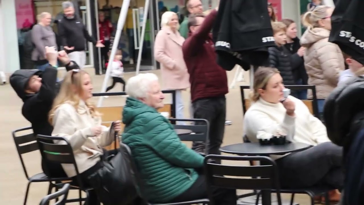Look what happens when a busker starts to sing at a local shopping mall!