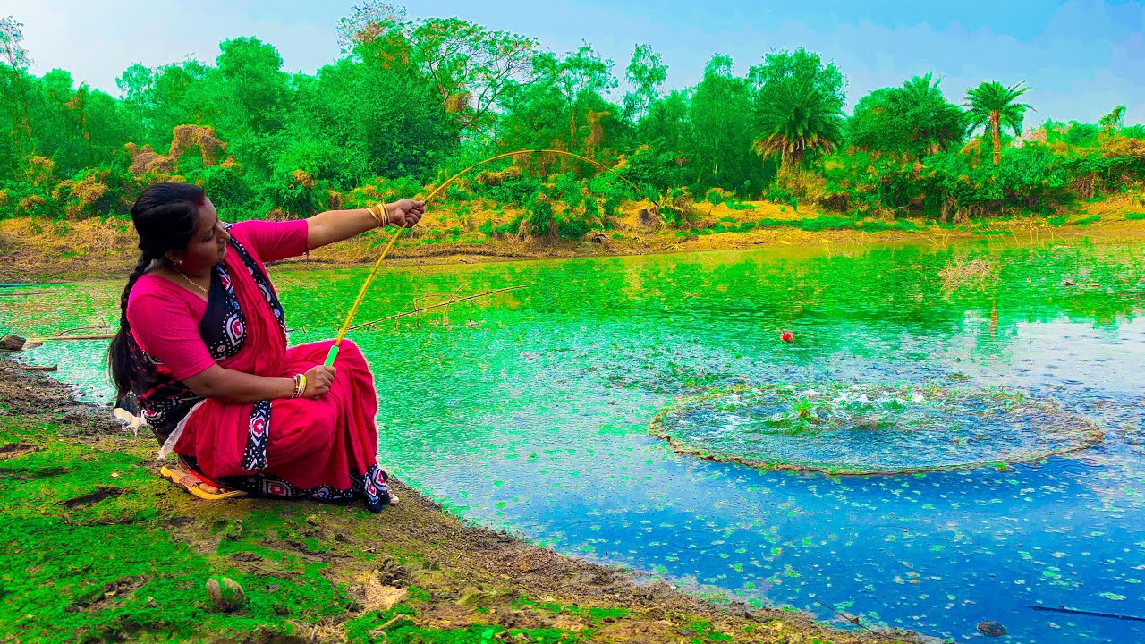 A cute girl is catching fish with a fishing rod using bait she collected from nature