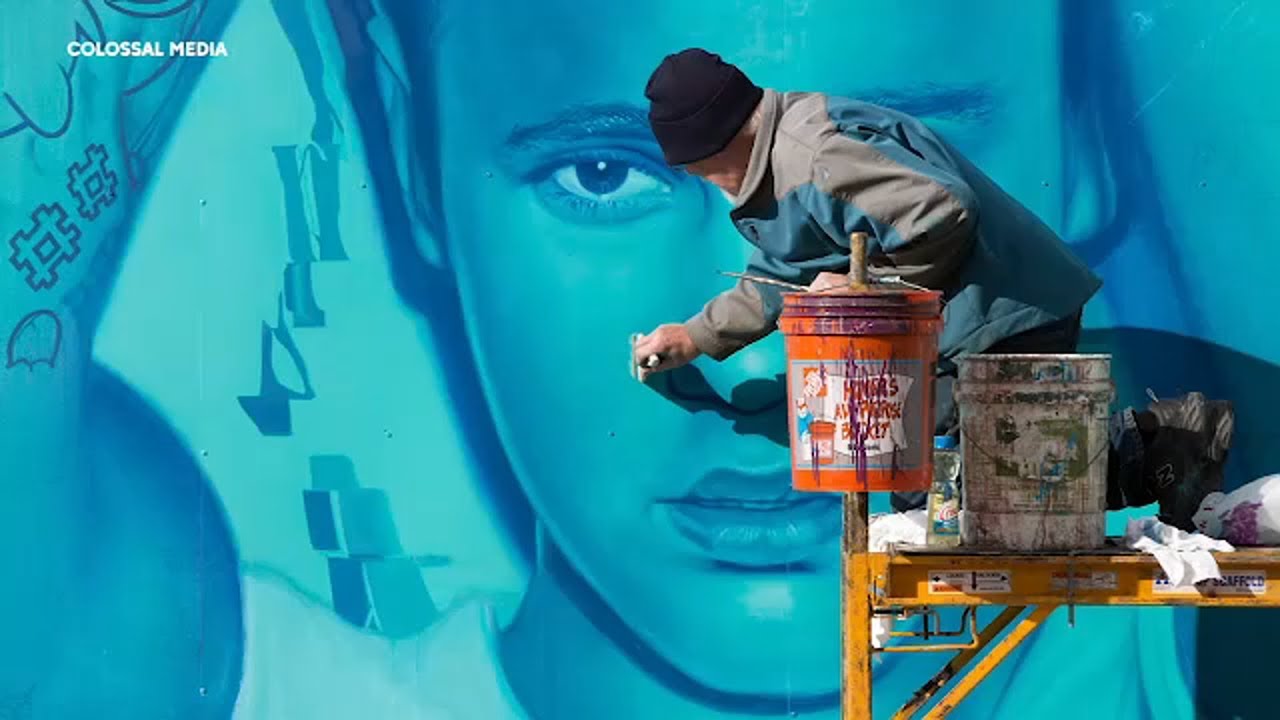 Artists dangle from buildings to hand paint massive billboards | In Our Backyard