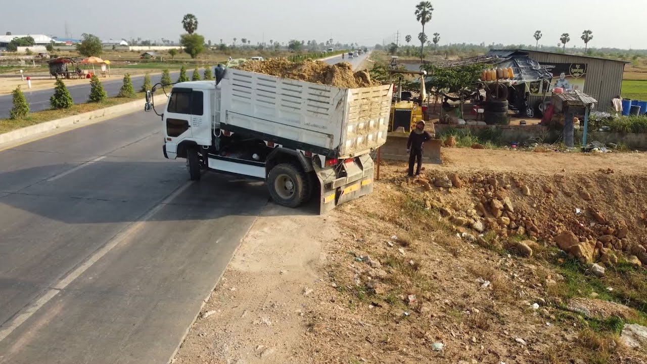 Technique! filling land Next to the road Use D31P KOMATSU Dozer With Small Dump Trucks.