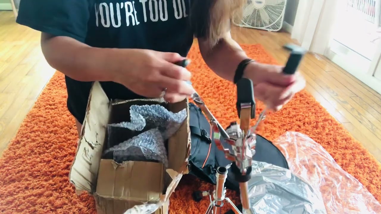 Lady drummer. Unboxing Drum Pad for stick exercises