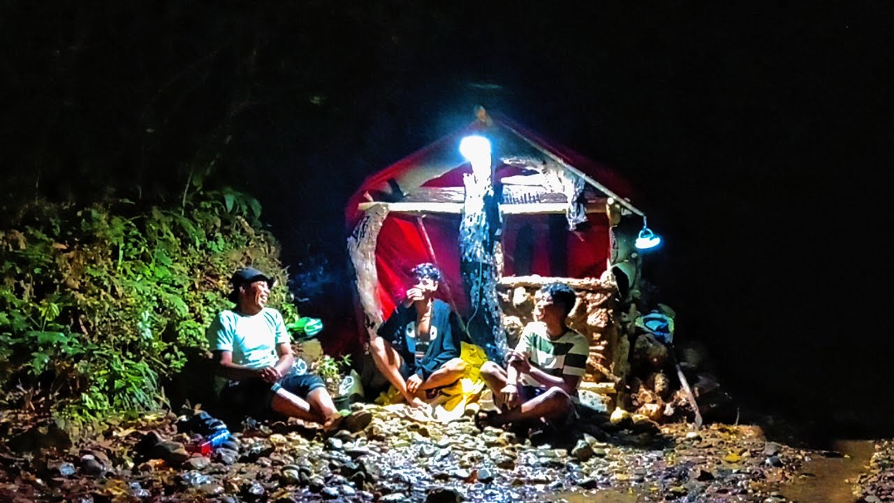 Camping hujan deras di pinggir sungai membangun rumah batu santai menikmati malam