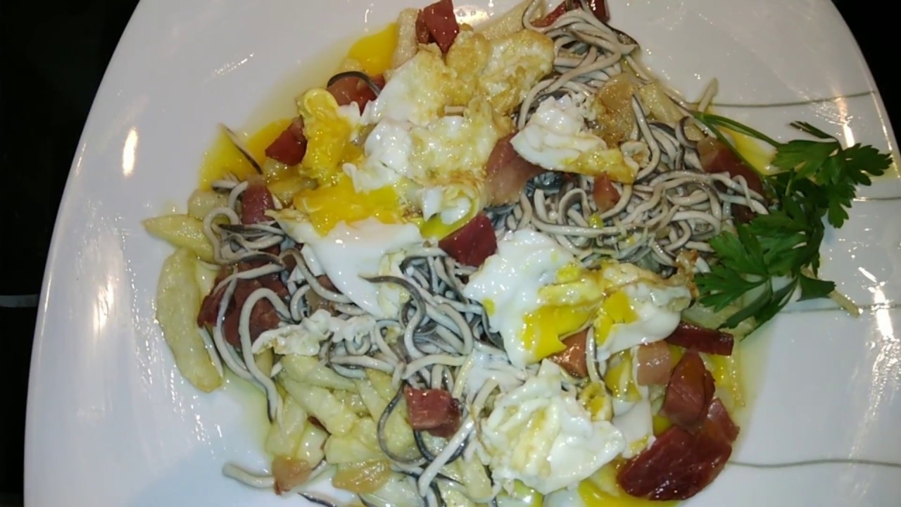 Huevos rotos con gulas y jamón