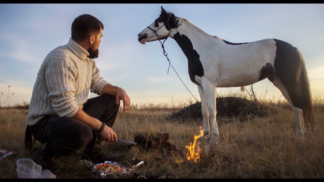 Journey on horseback to the valley of a large river. Bushcraft. Potatoes in bacon on charcoal.