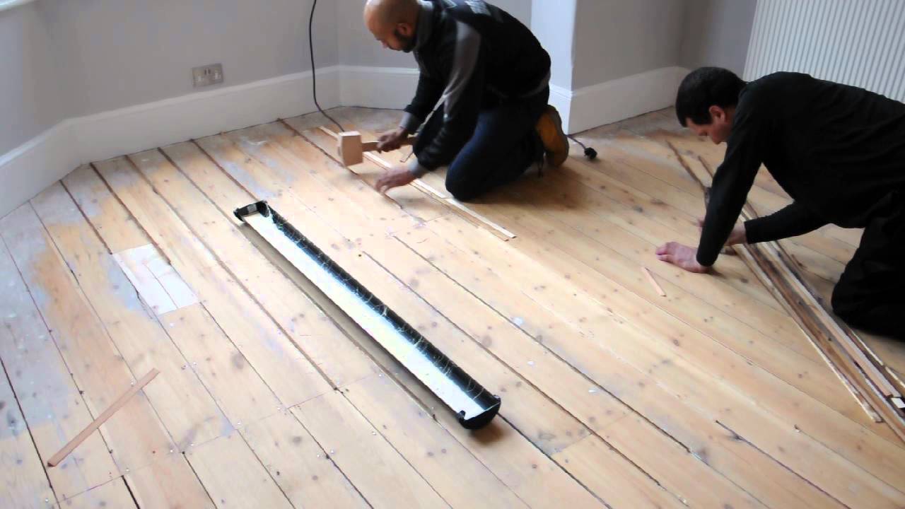 filling gaps in-between floorboards with reclaimed slivers of wood