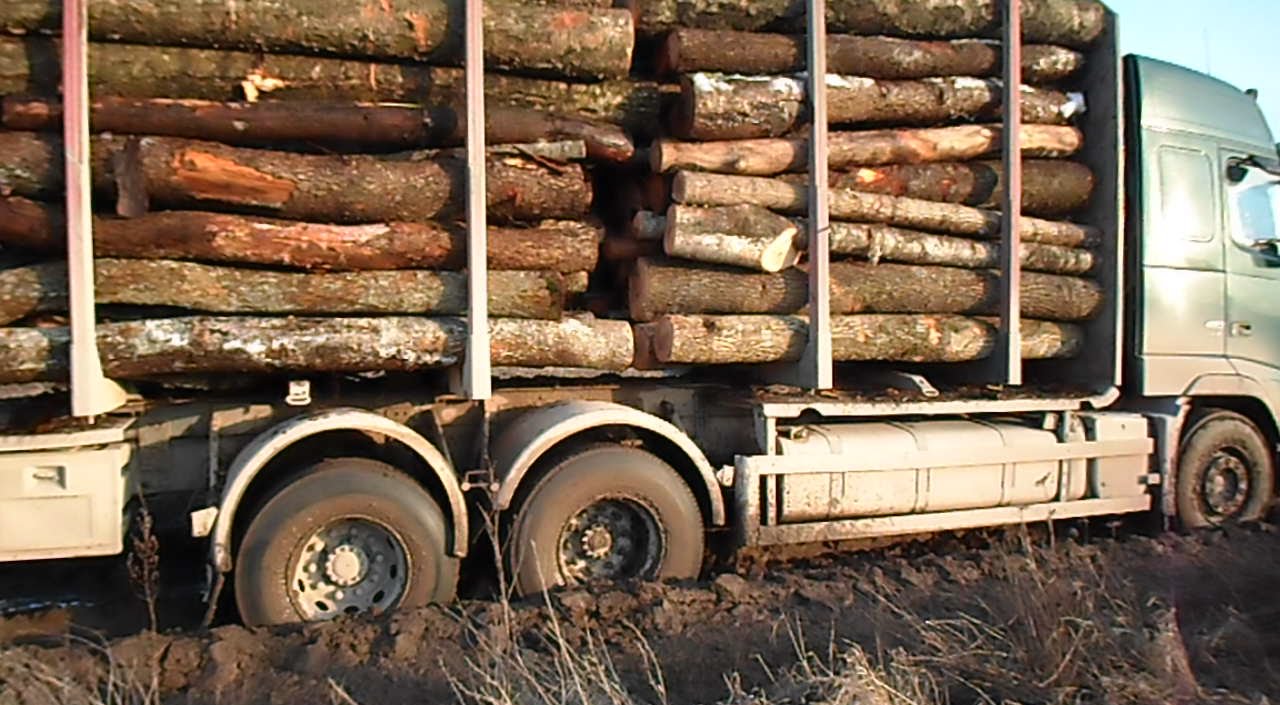 Fully loaded Volvo timber truck stuck in mud