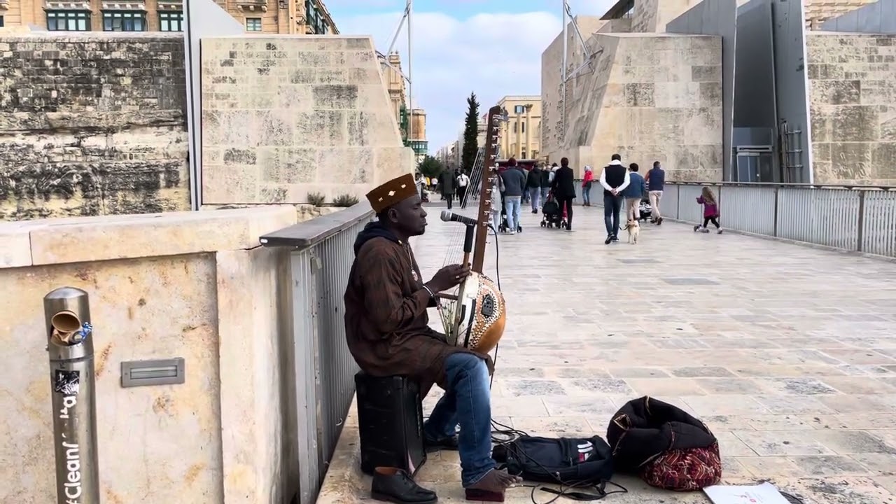 African busker plays kora