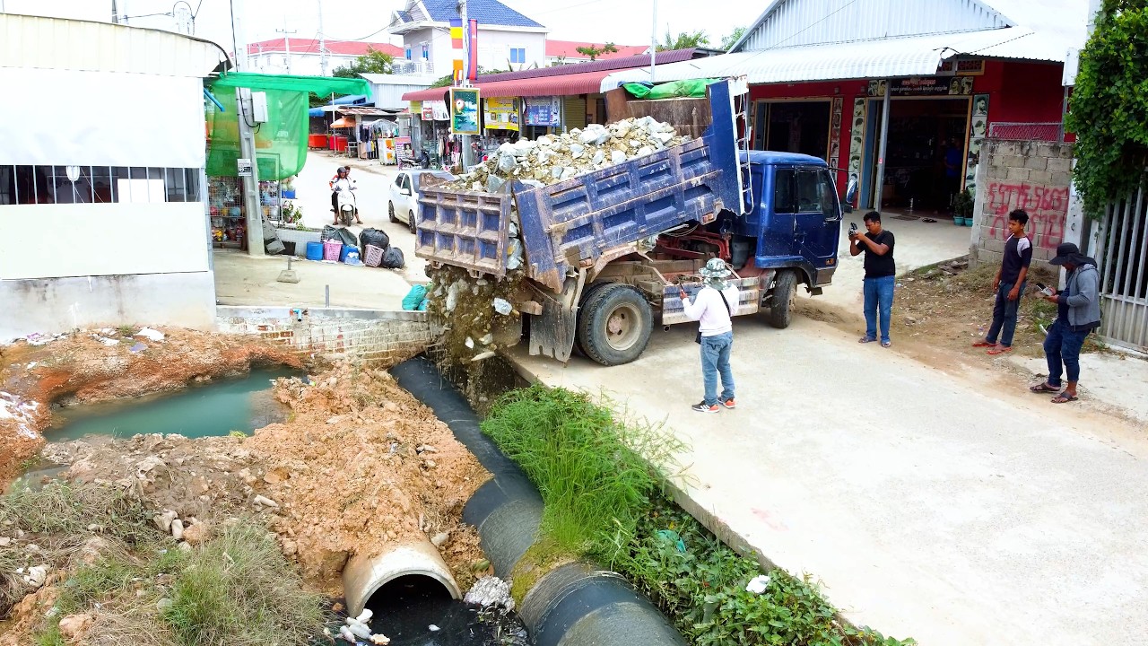 Dump truck unload stone cover the drain and flood land use BULLDOZER D20P complete the job