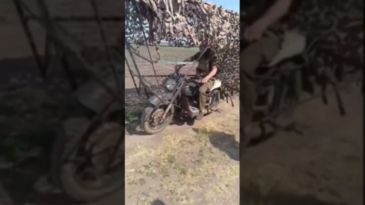 #Russian soldier driving a motorcycle with anti-drone cope cage