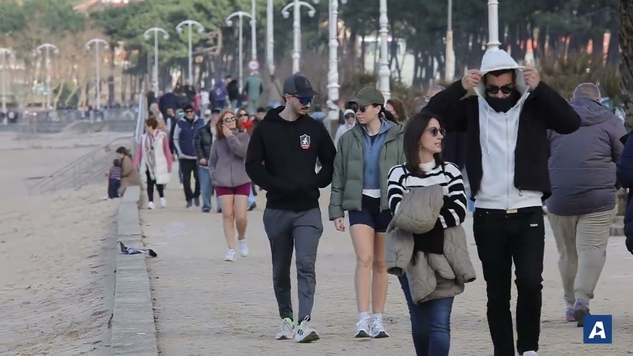 El regreso del sol abarrota el Paseo de Samil, lleno de arena tras los últimos temporales