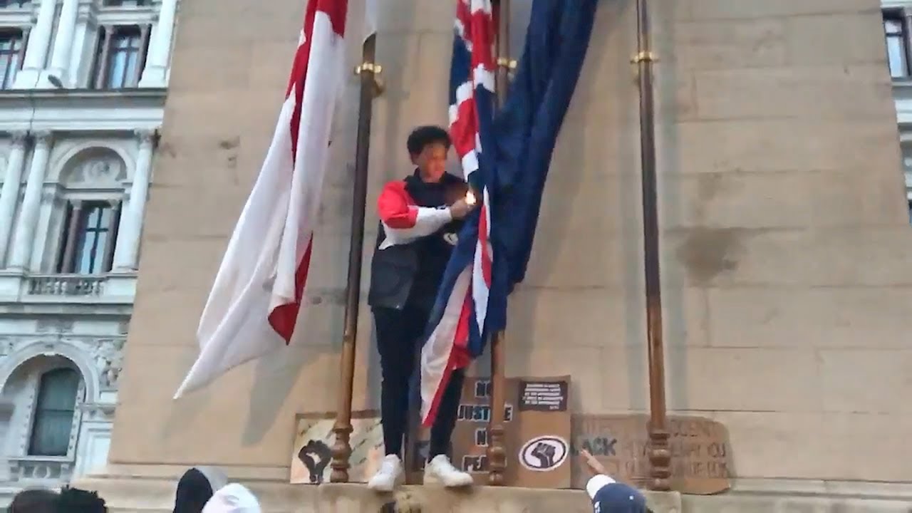 Protester appears to try to set a Union Jack on fire in London
