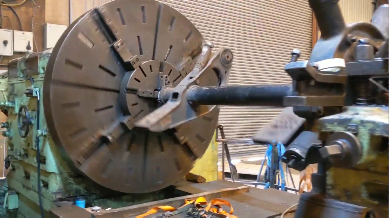Giant lathe machine machining turning new threads on truck axle engineering shop