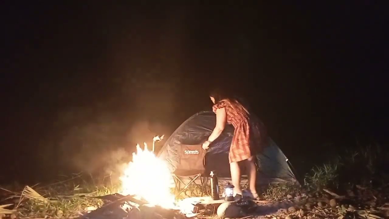 solo overnight camping , young woman - relaxing in the tent with the satisfying sound of nature