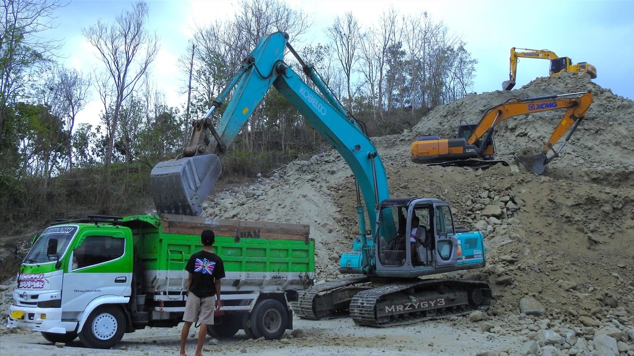 Trucks Excavator Moving Dirt from the Hill Top Road Construction