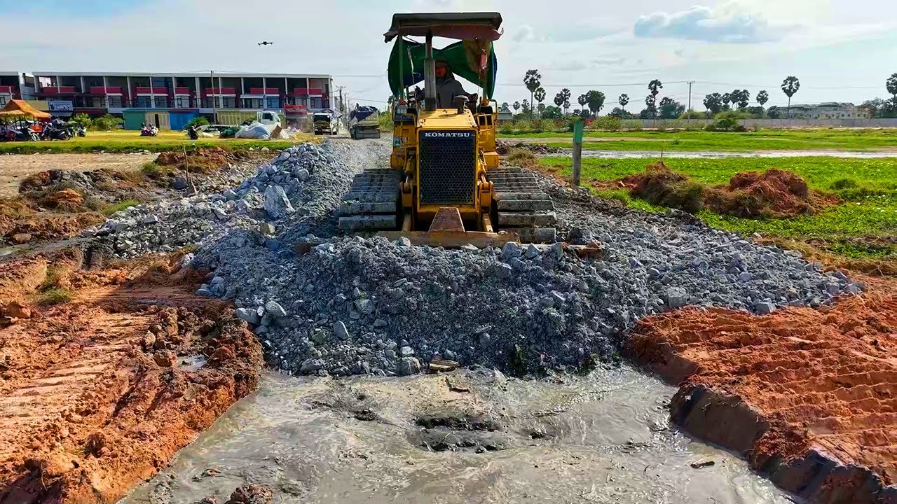 2Video delete canal to build new road by power dozer D31 pour stone with dump truck nearby complete