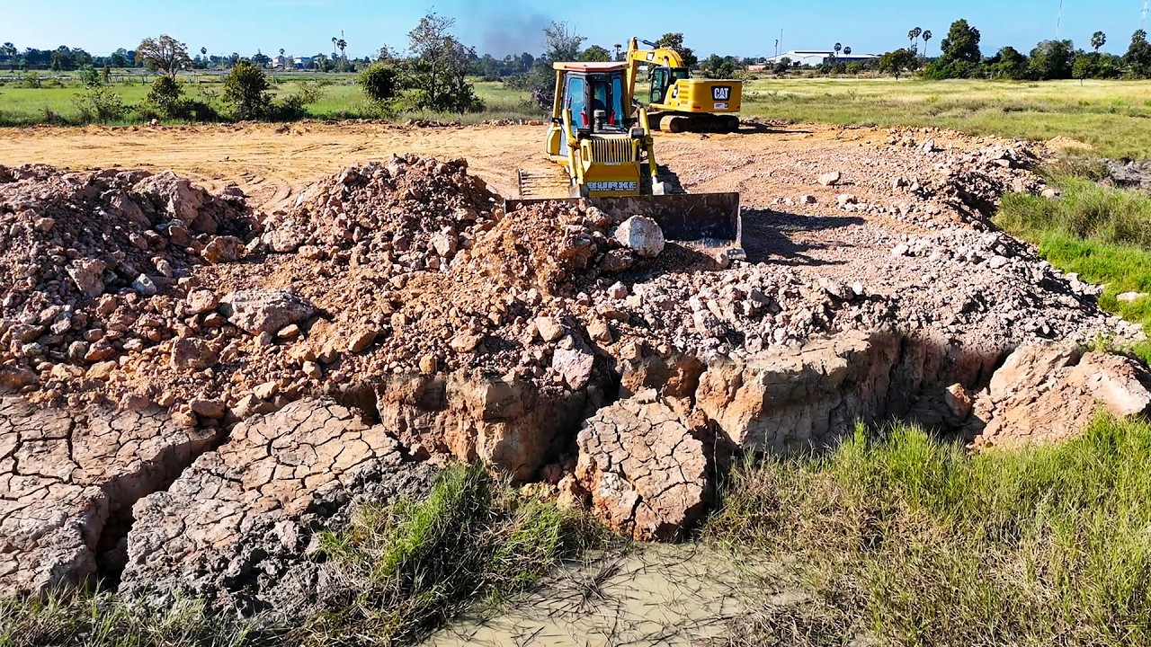 Huge bulldozer shows awesome skill filling up a farm with soil including dump truck carrying dirt