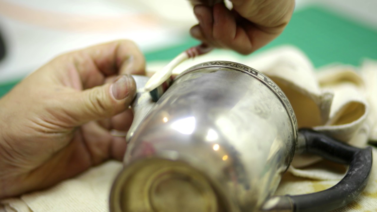 Polishing an old silver Teapot