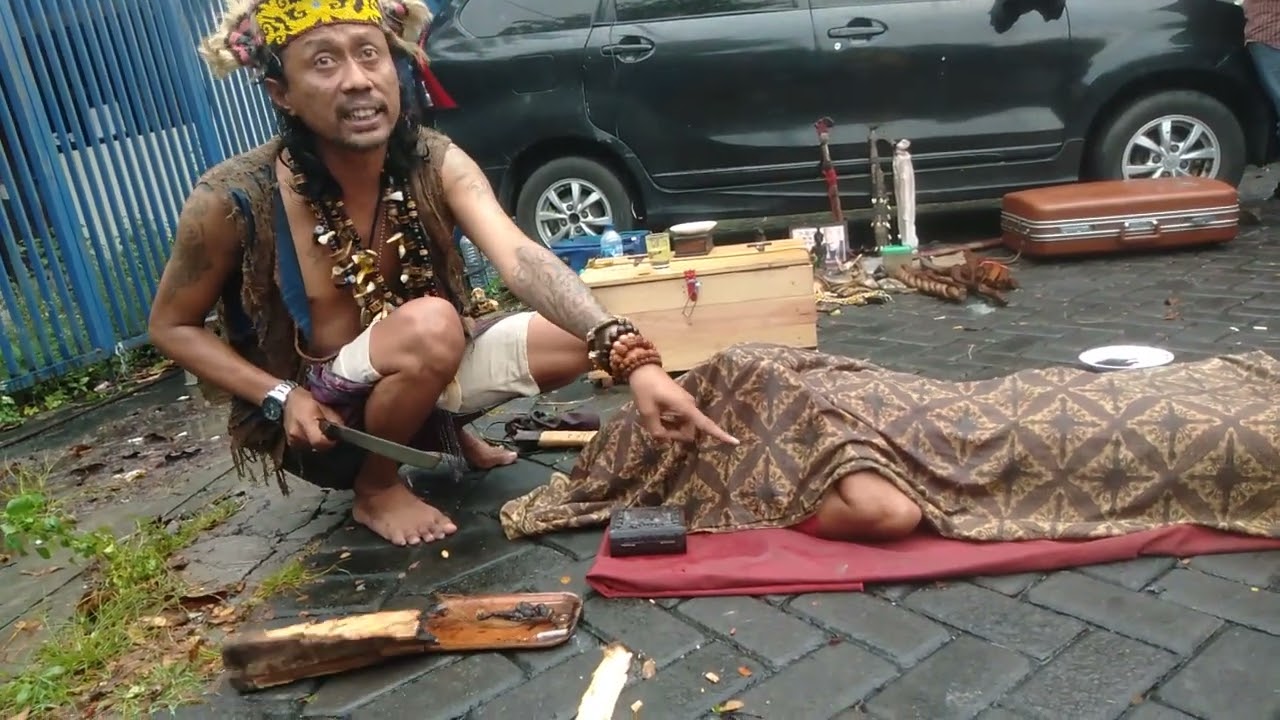atraksi debus dari kalimantan di pinggir jalan soekarno kota surabaya
