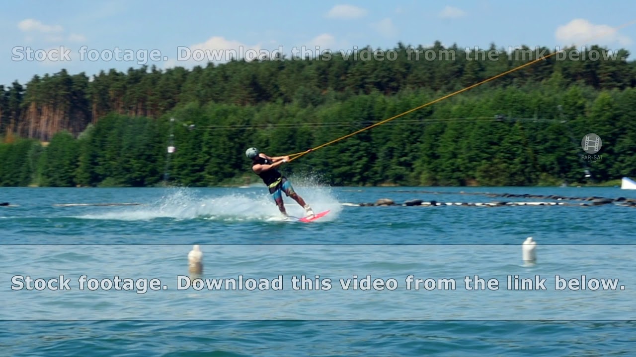 Beautiful and professional wakeboarder trains on wake board in summer cable park