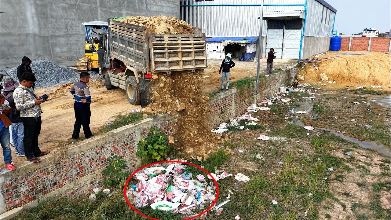 Incredible !! Team dump truck waiting unloading soil landfill with skill operator bulldozer pushing 