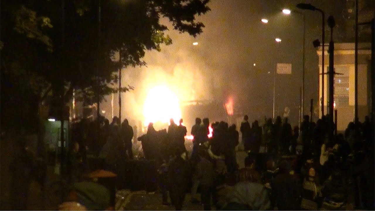 Vehicles Explode as Riot Police Baton Charge