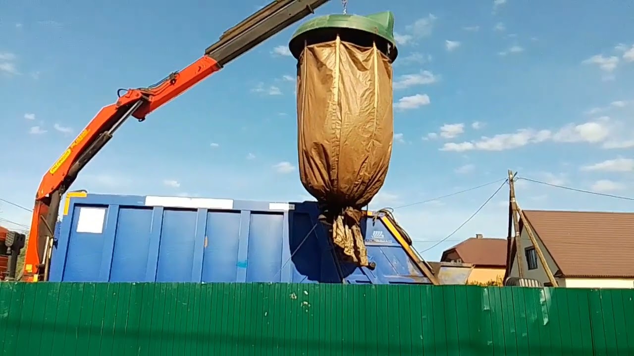 Мусоровоз КАМАЗ грузит баки