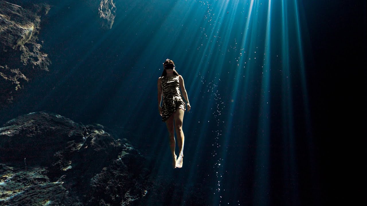 Freedive with light beams at Cenote El Pit (the Pit), Tulum Mexico