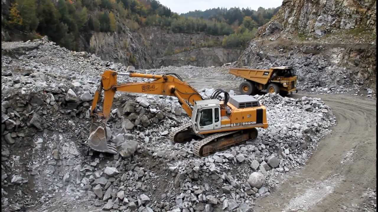 Liebherr R964B loads CAT 775E and breaking rocks