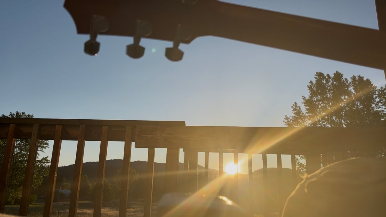 A guitar, a pop bottle, a harmonica, and a beautiful sunset.