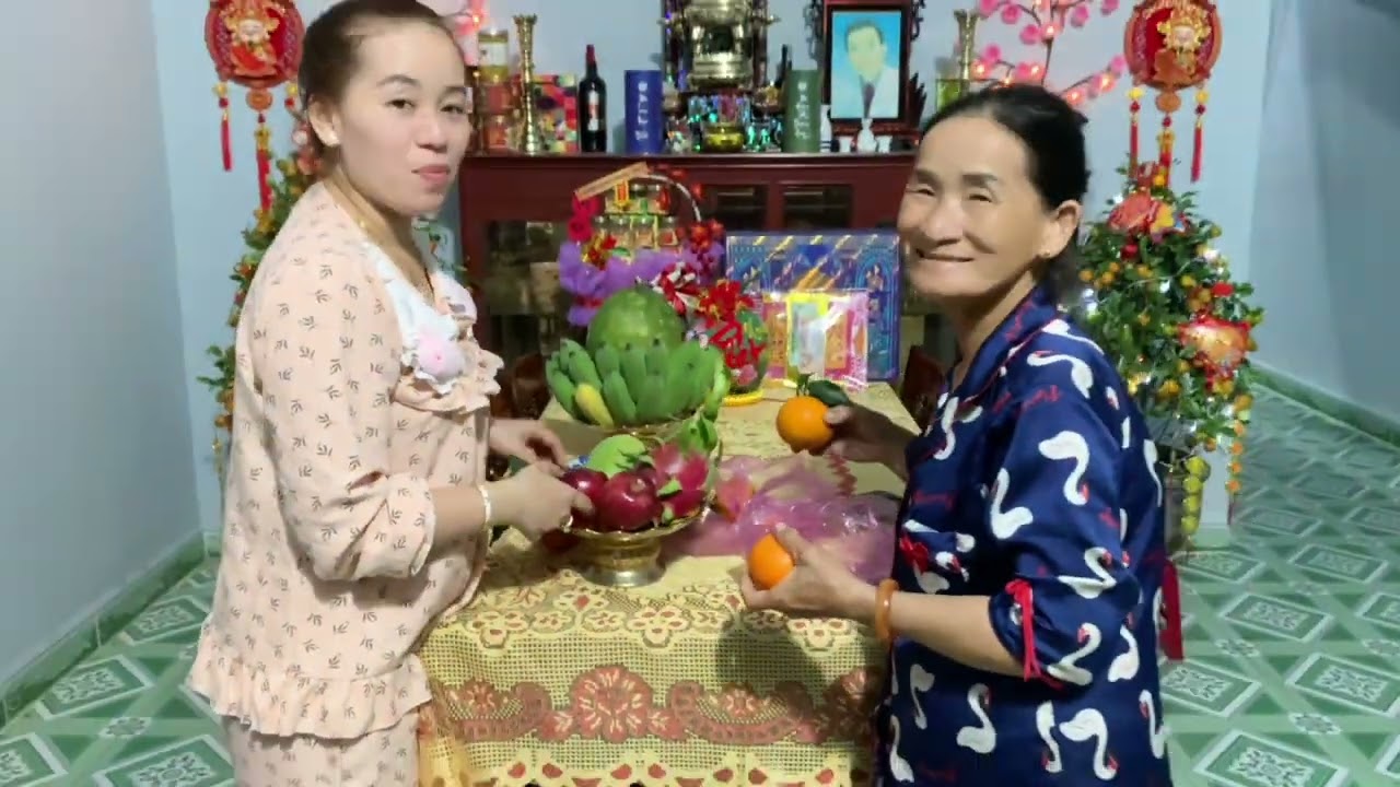 2 mẹ  con tranh thủ trang trí mâm quả bình hoa để chuẩn bị đón giao thừa