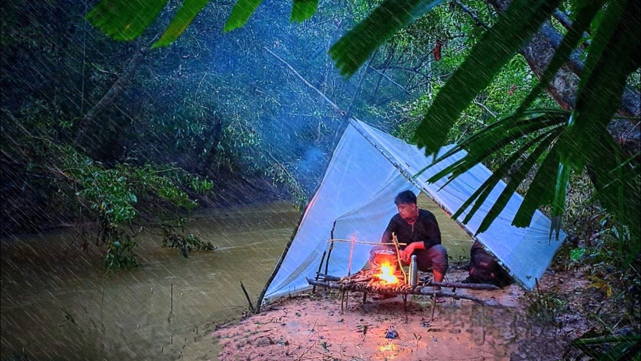 Solo camping and cooking with heavy rain close to the river.