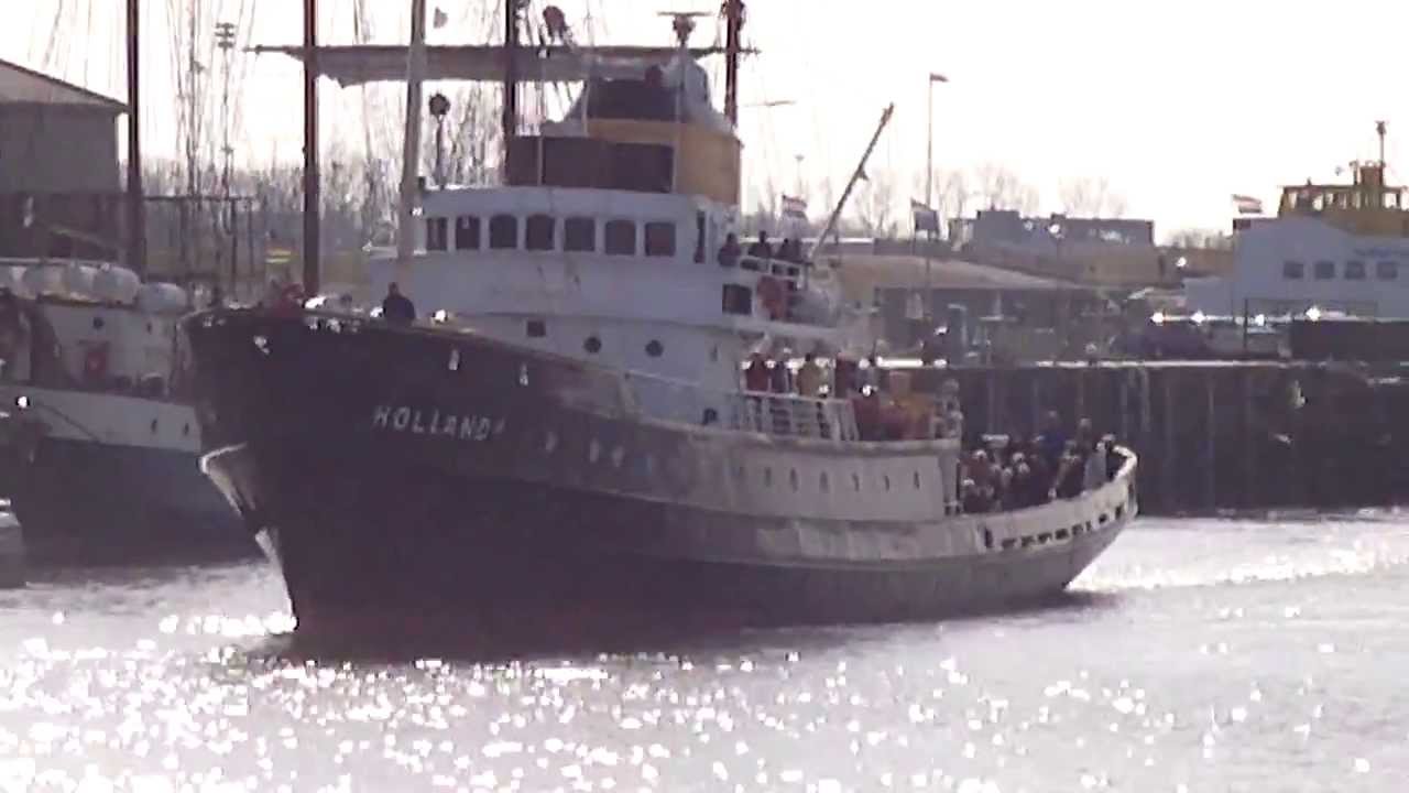 Zeesleepboot Holland vaart de haven van Harlingen uit.