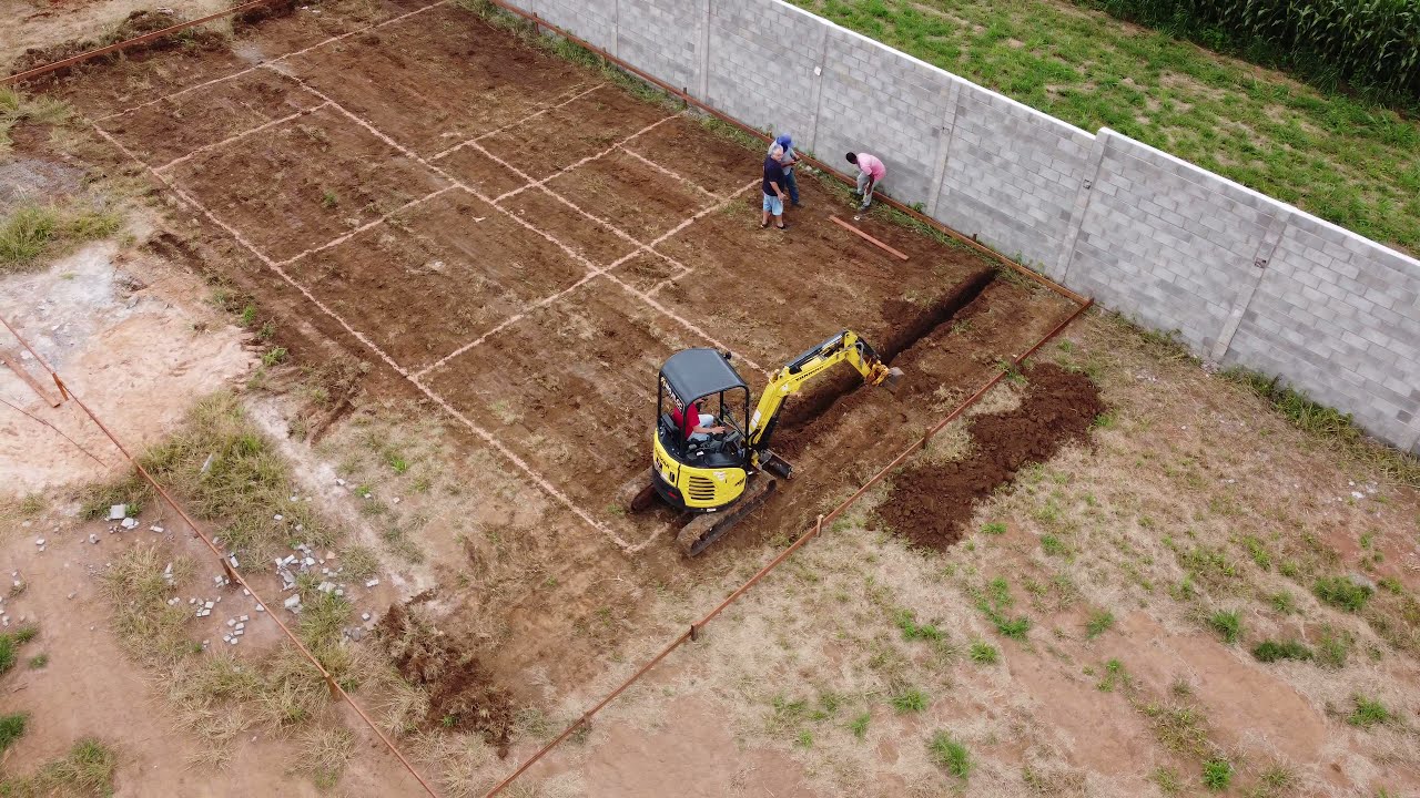 Mini escavadeira cavando alicerce , vis&atilde;o do drone