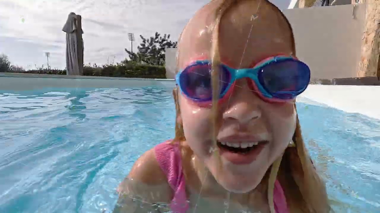 Girl playfully splashing pool water