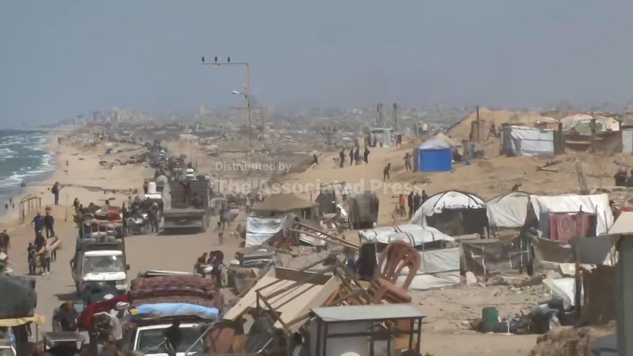 Smoke plumes rise in distance as Palestinians flee from the north to the south of Gaza