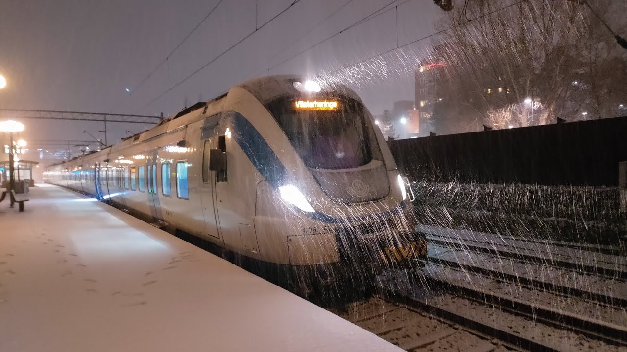 En X60B kopplas om från långt tåg till kort tåg vid Kungsängen i snöoväder.