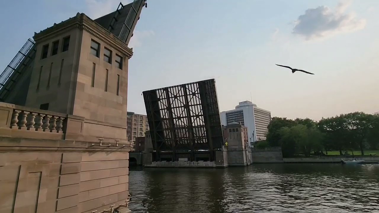 Milwaukee draw bridge opens up to let boats pass, pedestrians walk and jump before it fully closes