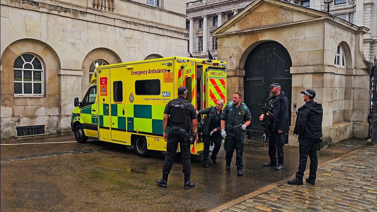 EMERGENCY AMBULANCE ARRIVES AT HORSE GUARDS on a rainy day... but it's not for the tourists!