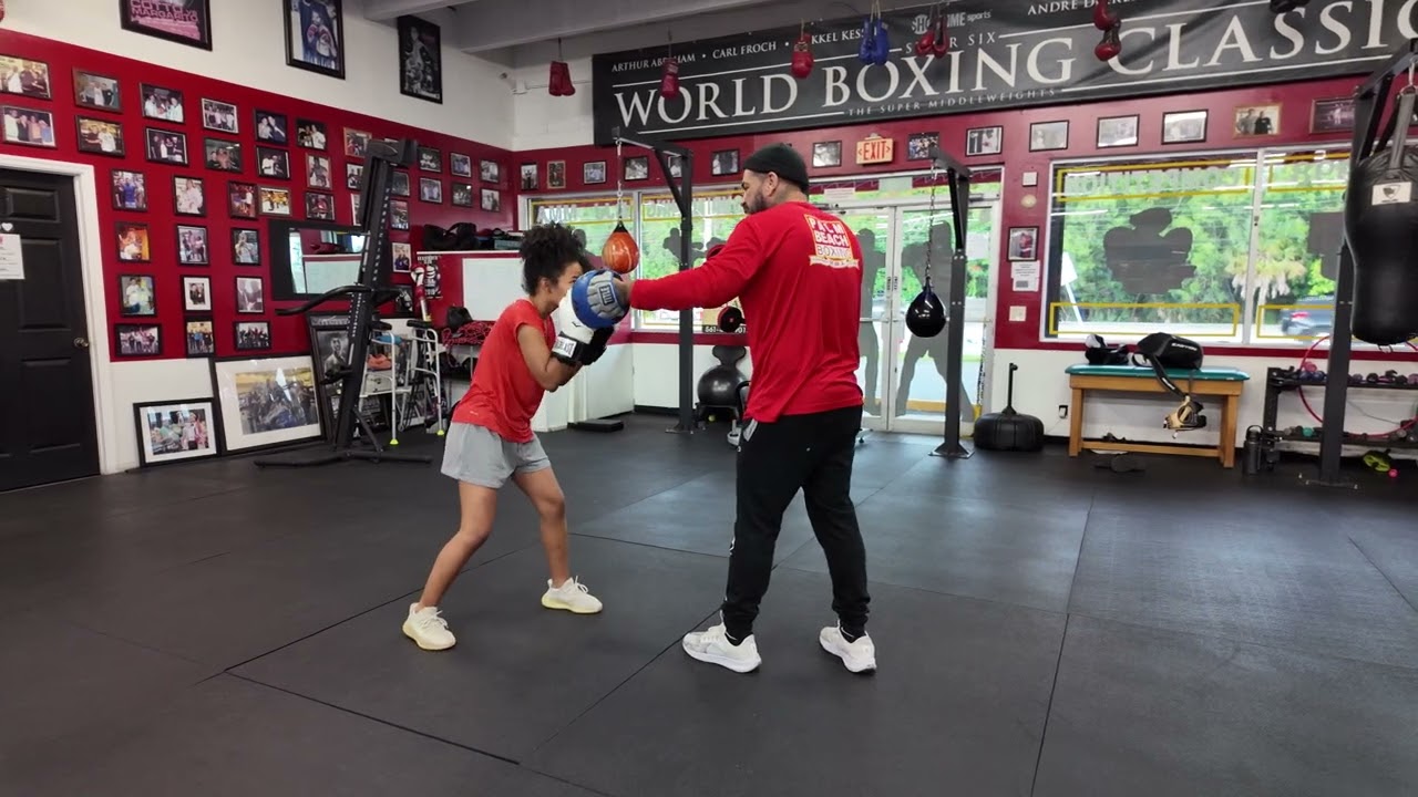 Coach Cisco one-on-one coaching with a Palm Beach Boxing & MMA client to learn combinations.