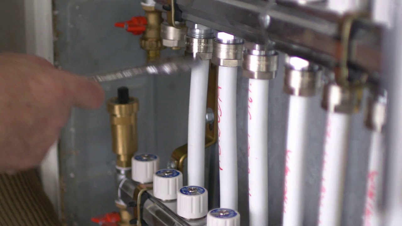 a man tightening the heating pipes of a central heating system