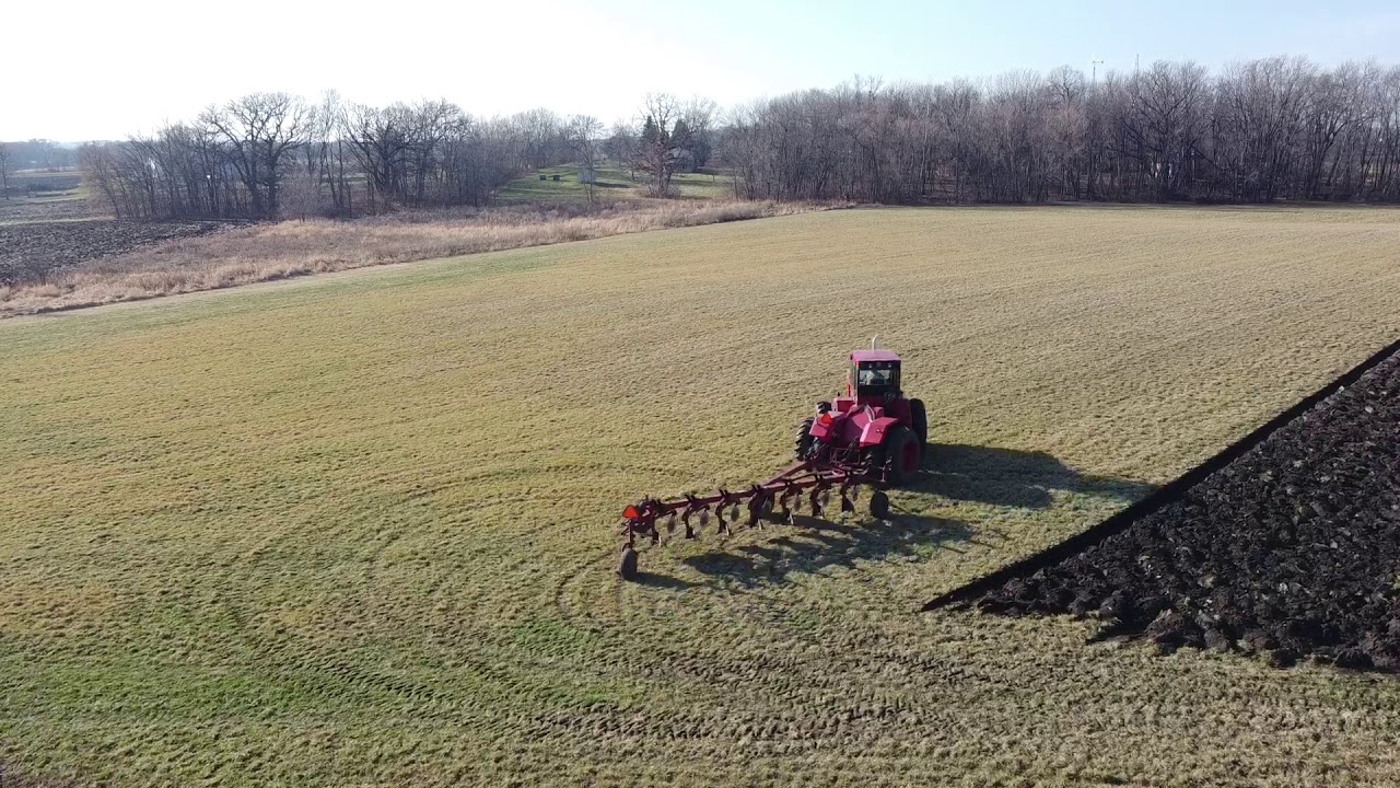 Neighbor plowing under a hay field with a 7 bottom plow