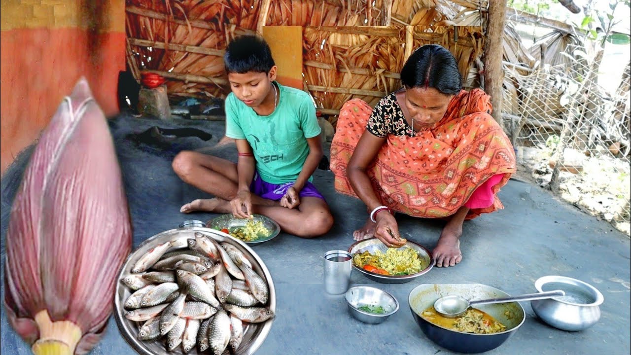 santali tribe mother cooking small fish curry with banana flower for her little son||rural village