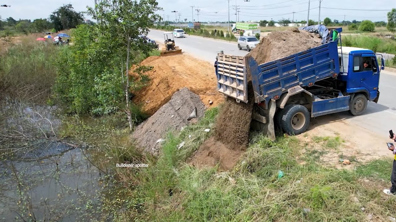 Great job !! Dump truck 5 unloading soil landfilling flooded with bulldozer pushing stone filling up