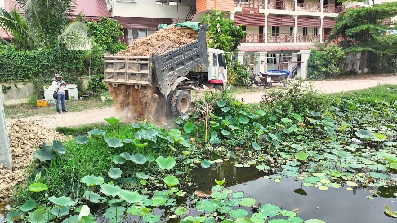 Development Equipment & Dump Truck Drops First Load of Soil into Water